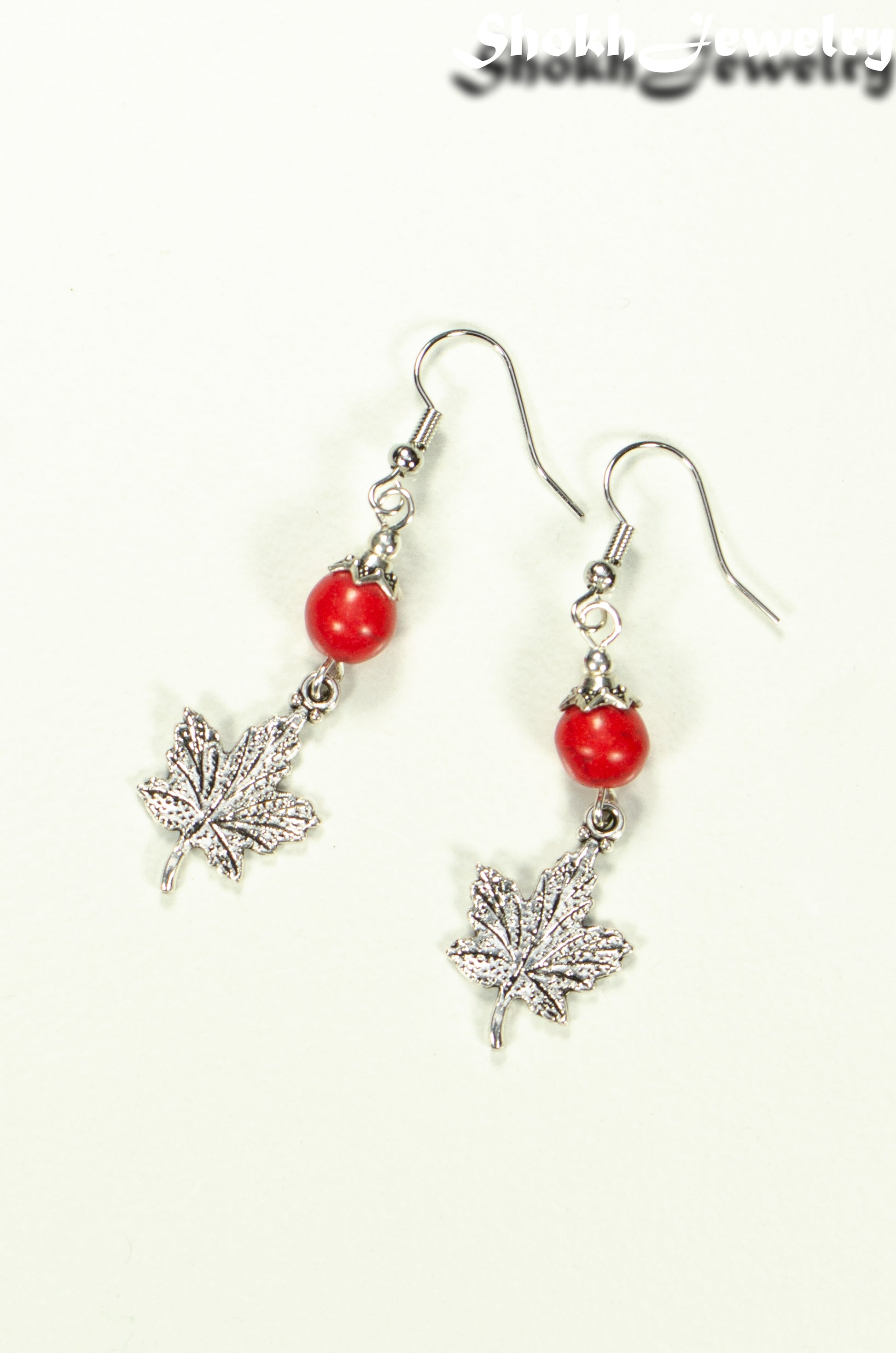 Top view of Red Howlite and Tibetan Silver Maple Leaf Dangle Earrings.