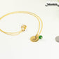 Gold Plated May Birth Flower Necklace with Emerald Birthstone Pendant beside a dime.