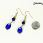 Navy Blue Oval Glass Dangle Earrings beside a dime.