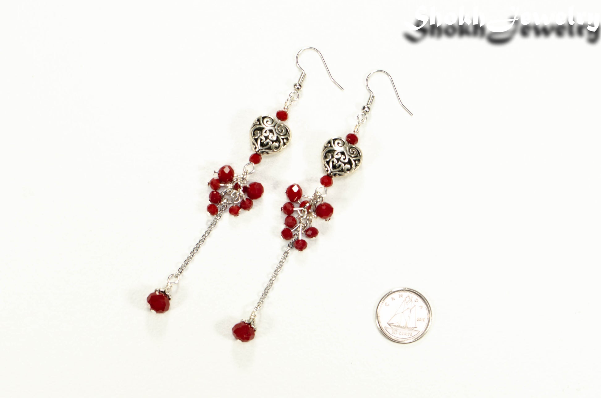 Statement Tibetan Silver Heart and Red Beaded Cluster Earrings beside a dime.