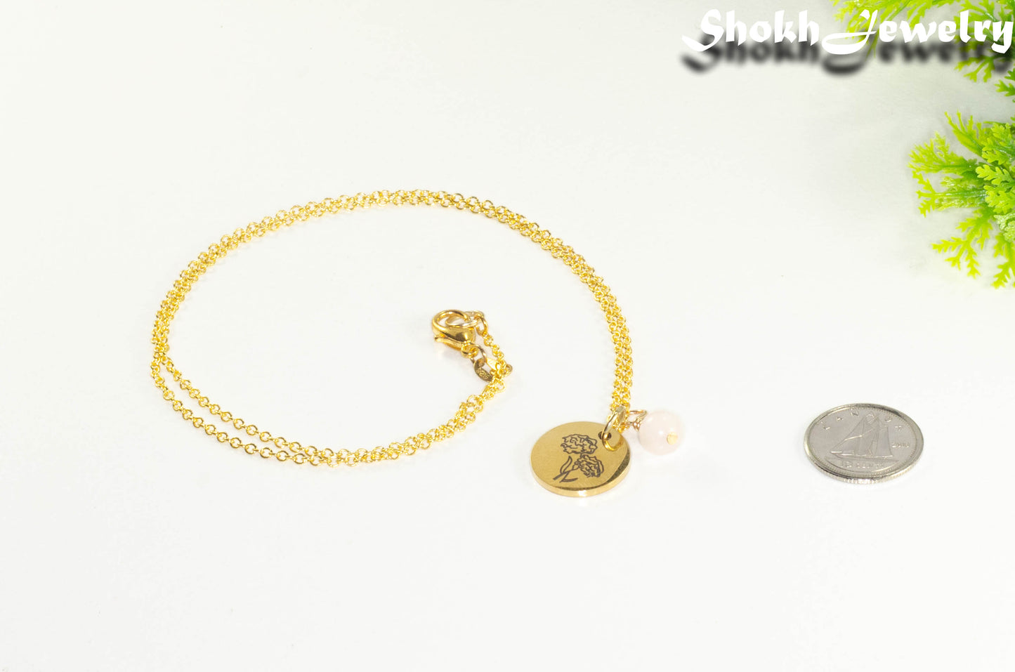 Gold Plated October Birth Flower Necklace with Rose Quartz Birthstone Pendant beside a dime.