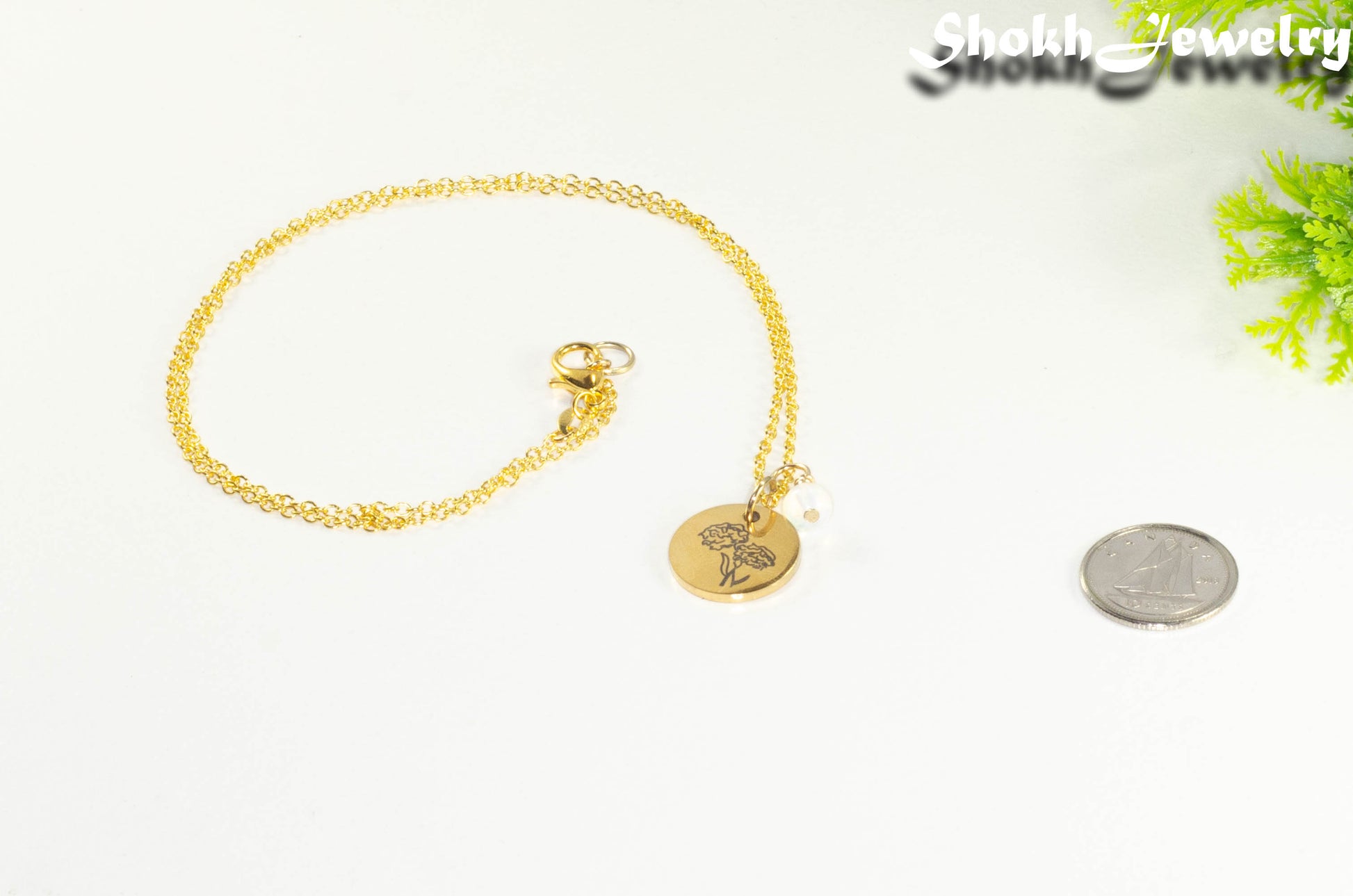 Gold Plated October Birth Flower Necklace with White Opal Birthstone Pendant beside a dime.