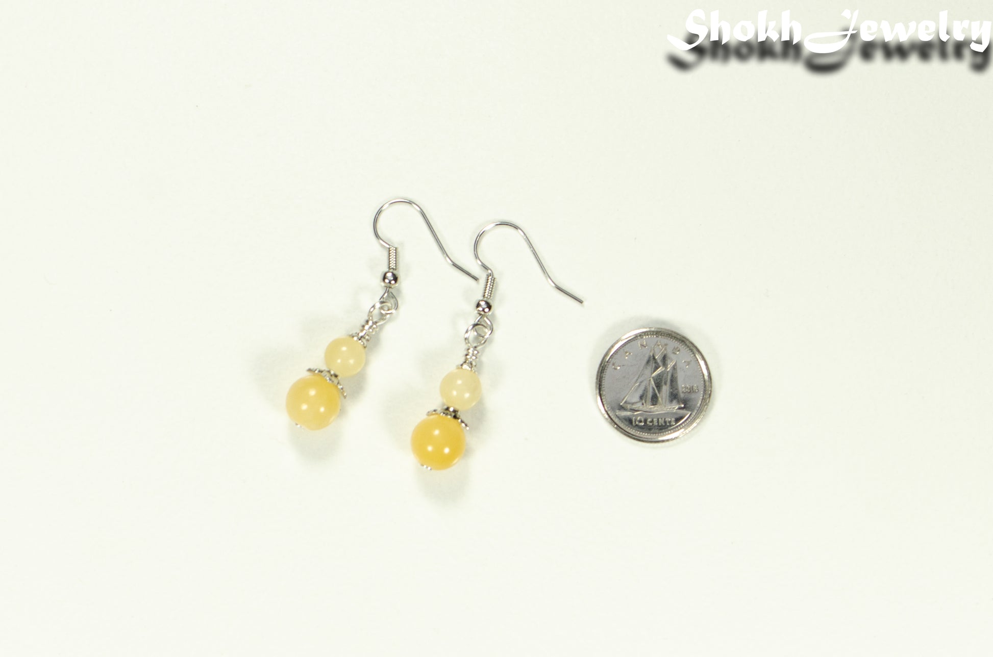 Small Natural Calcite Crystal Earrings beside a dime.