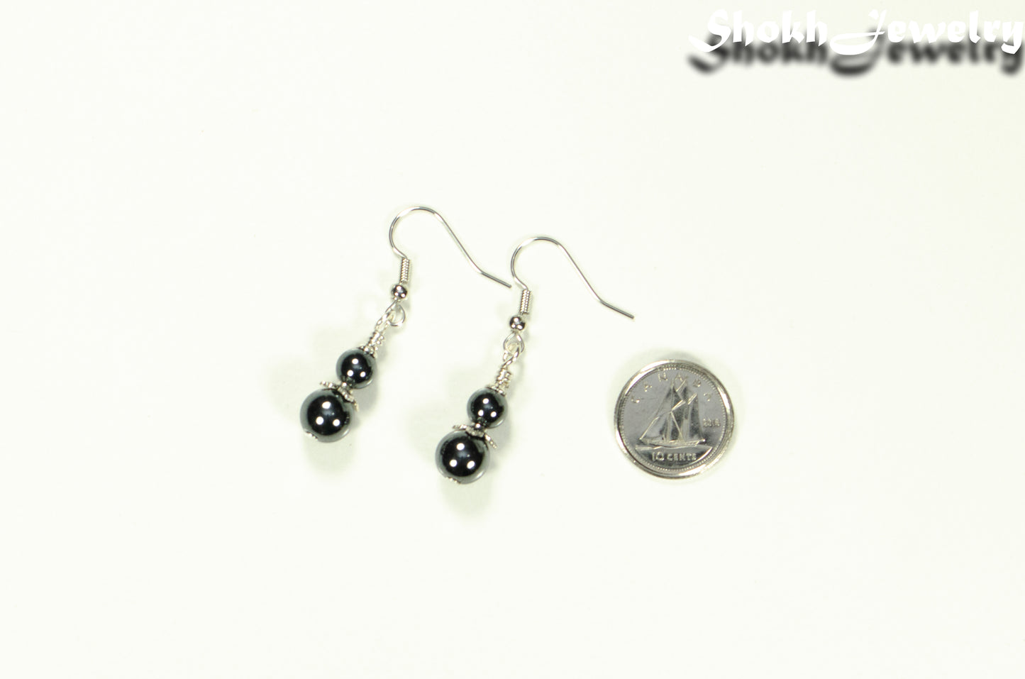 Small Natural Hematite Earrings beside a dime.