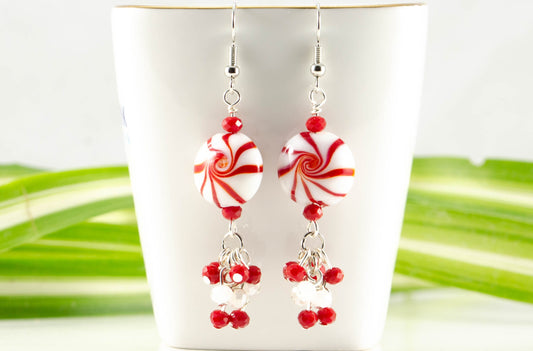 Statement Christmas Peppermint Glass Bead Earrings displayed on a tea cup.