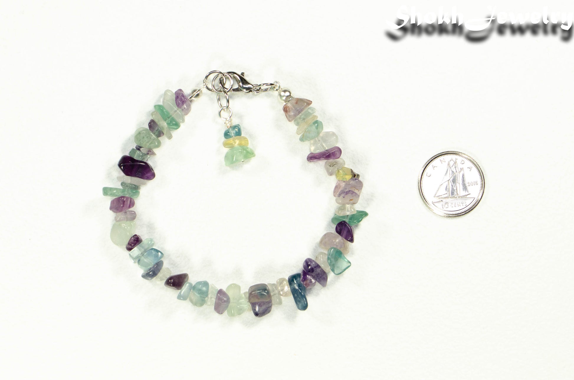 Natural Rainbow Fluorite Crystal Chip Bracelet beside a dime.