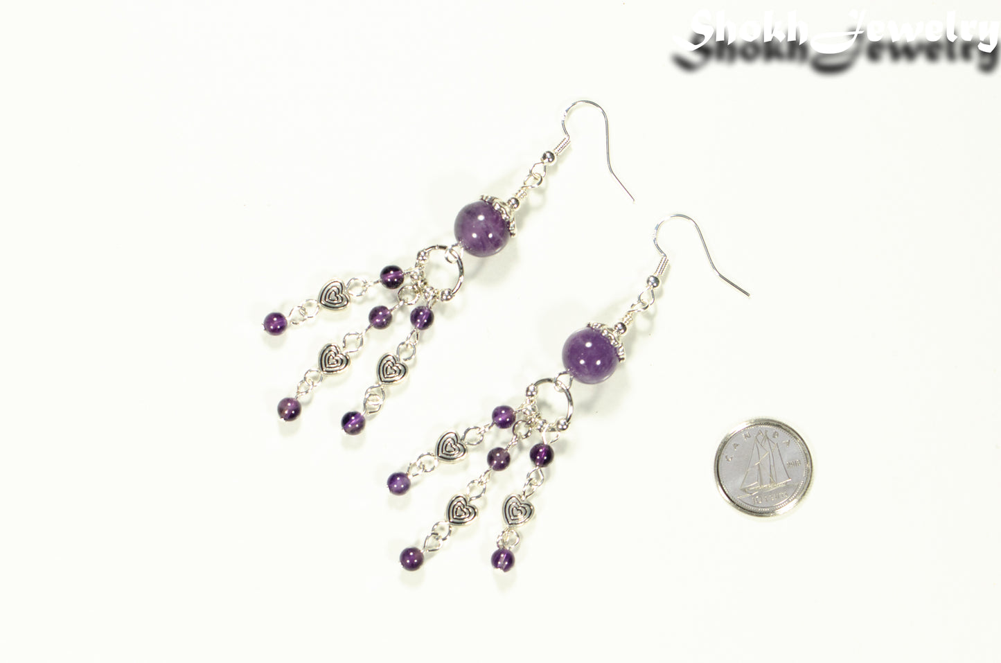 Statement Amethyst and Heart Chandelier Earrings beside a dime.