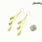 Long Gold Plated Chain and Peridot Chip Earrings beside a dime.