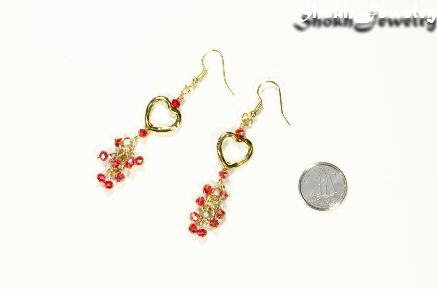 Gold Plated Heart and Red Crystal Cluster Earrings beside a dime.