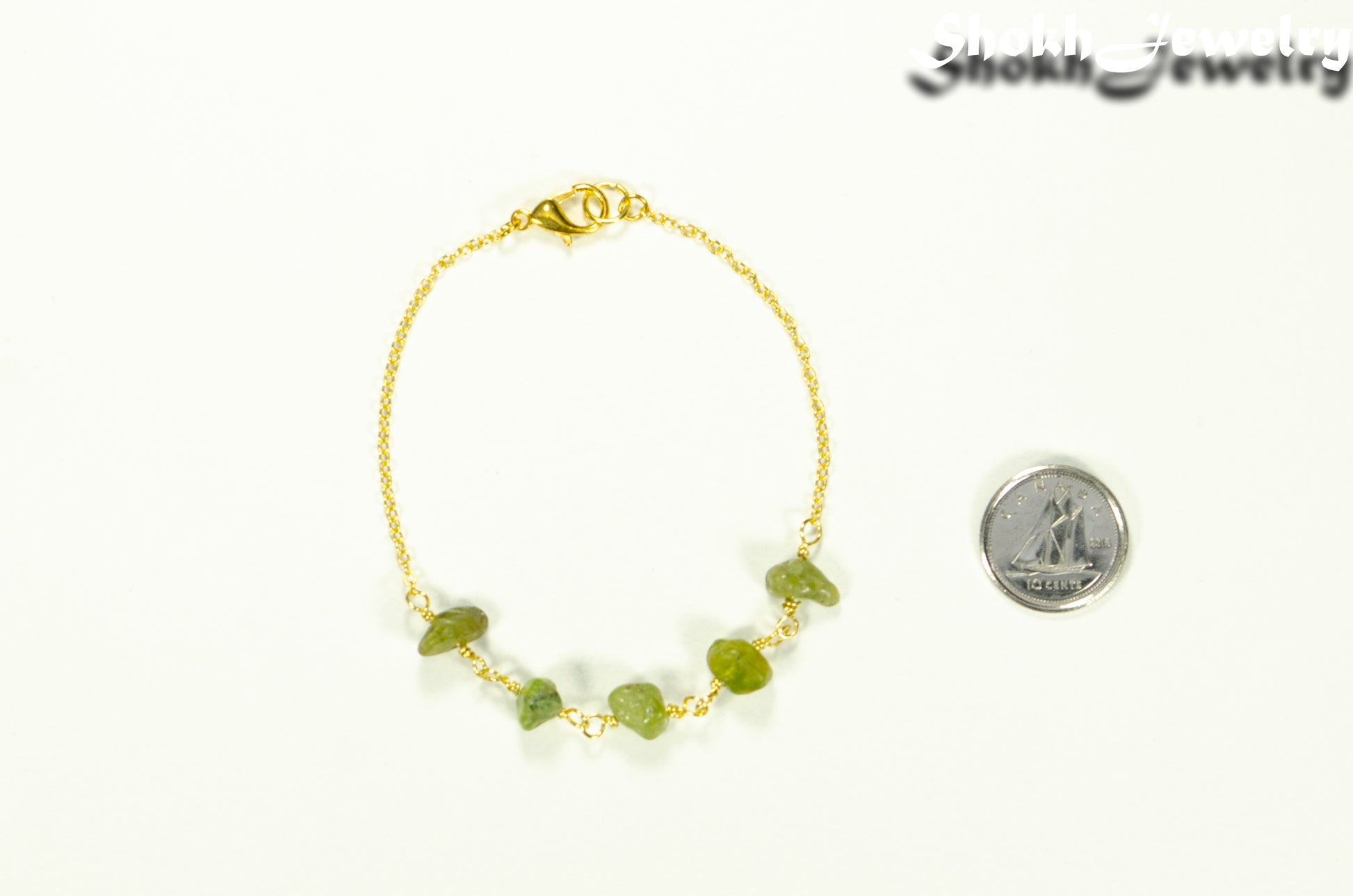 Peridot Crystal Chip and Gold Plated Chain Bracelet beside a dime.