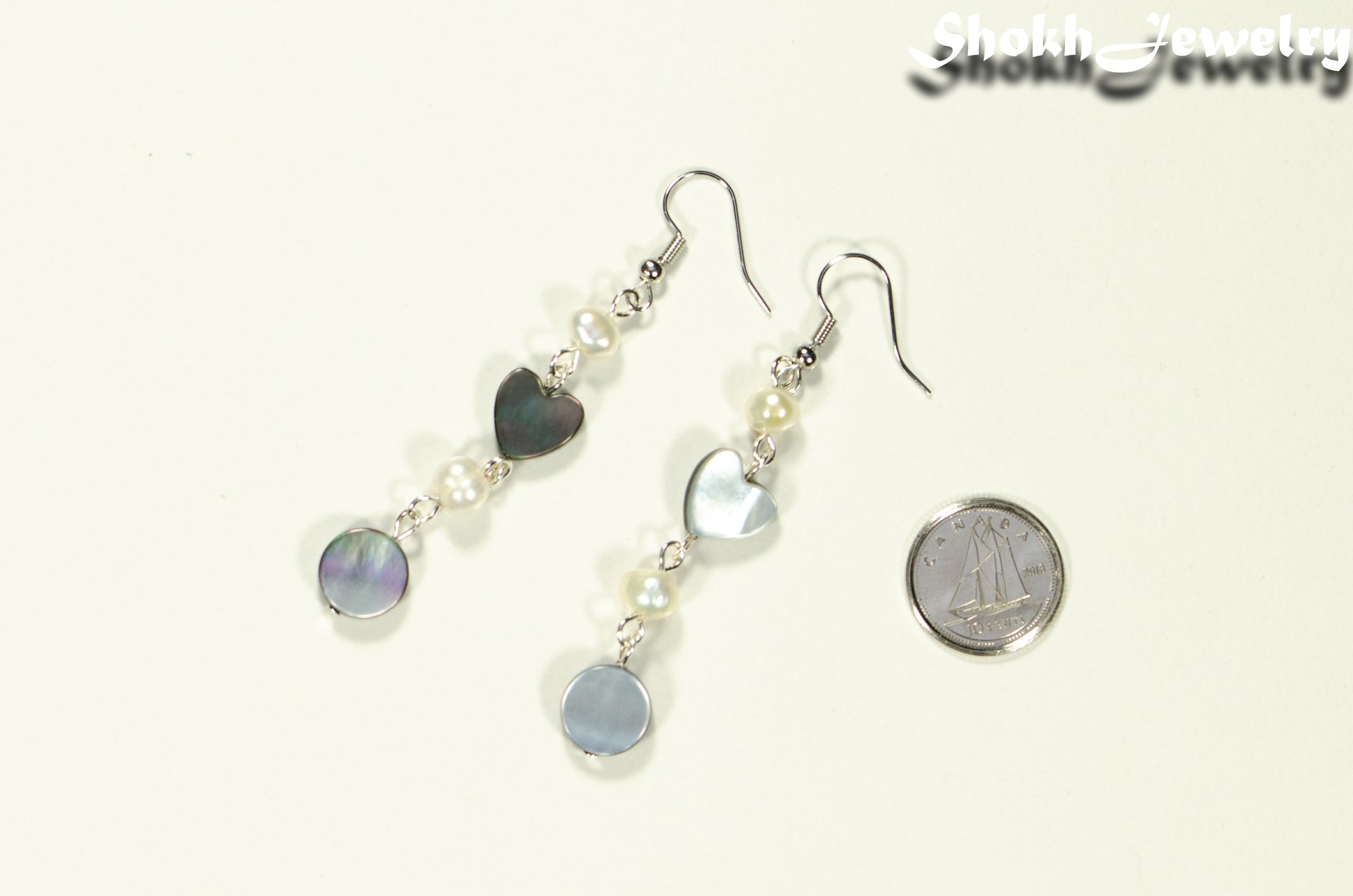 Long Grey Seashell and Freshwater Pearl Earrings beside a dime.