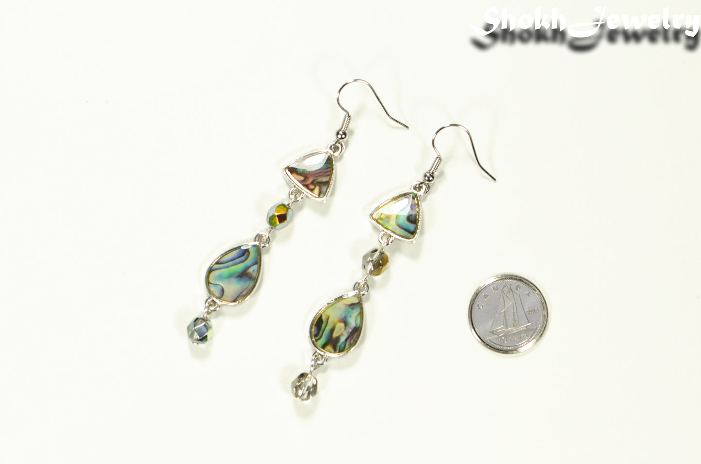 Long Abalone Shell and Glass Crystal Earrings beside a dime.