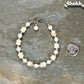 Freshwater Pearl and Seashell Bracelet with Clasp beside a dime.