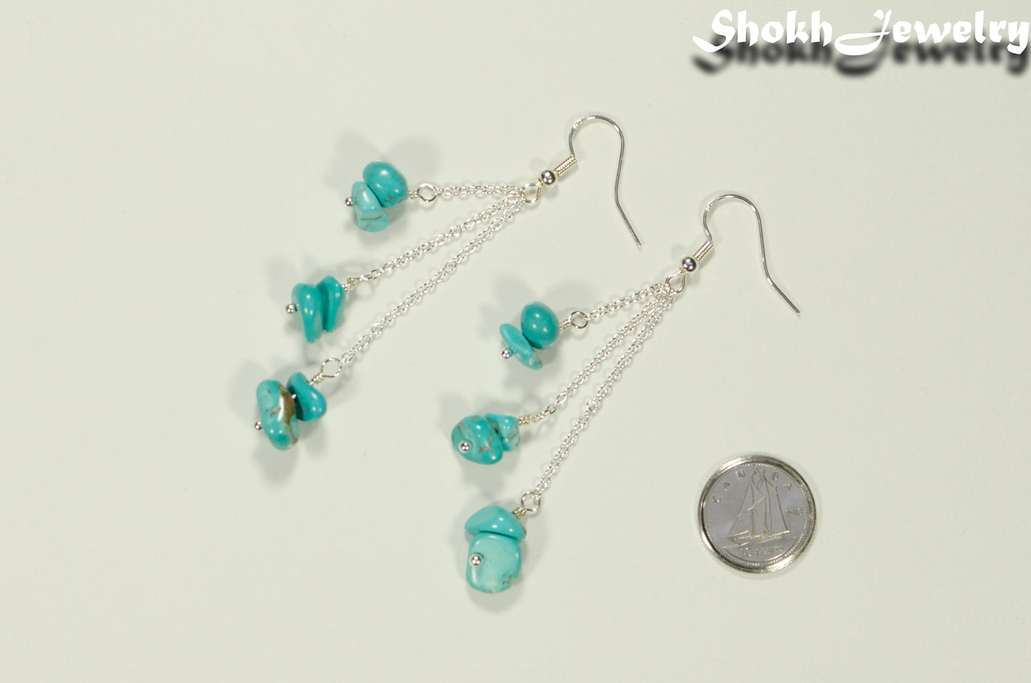 Long Silver Plated Chain and Turquoise Crystal Chip Earrings beside a dime.