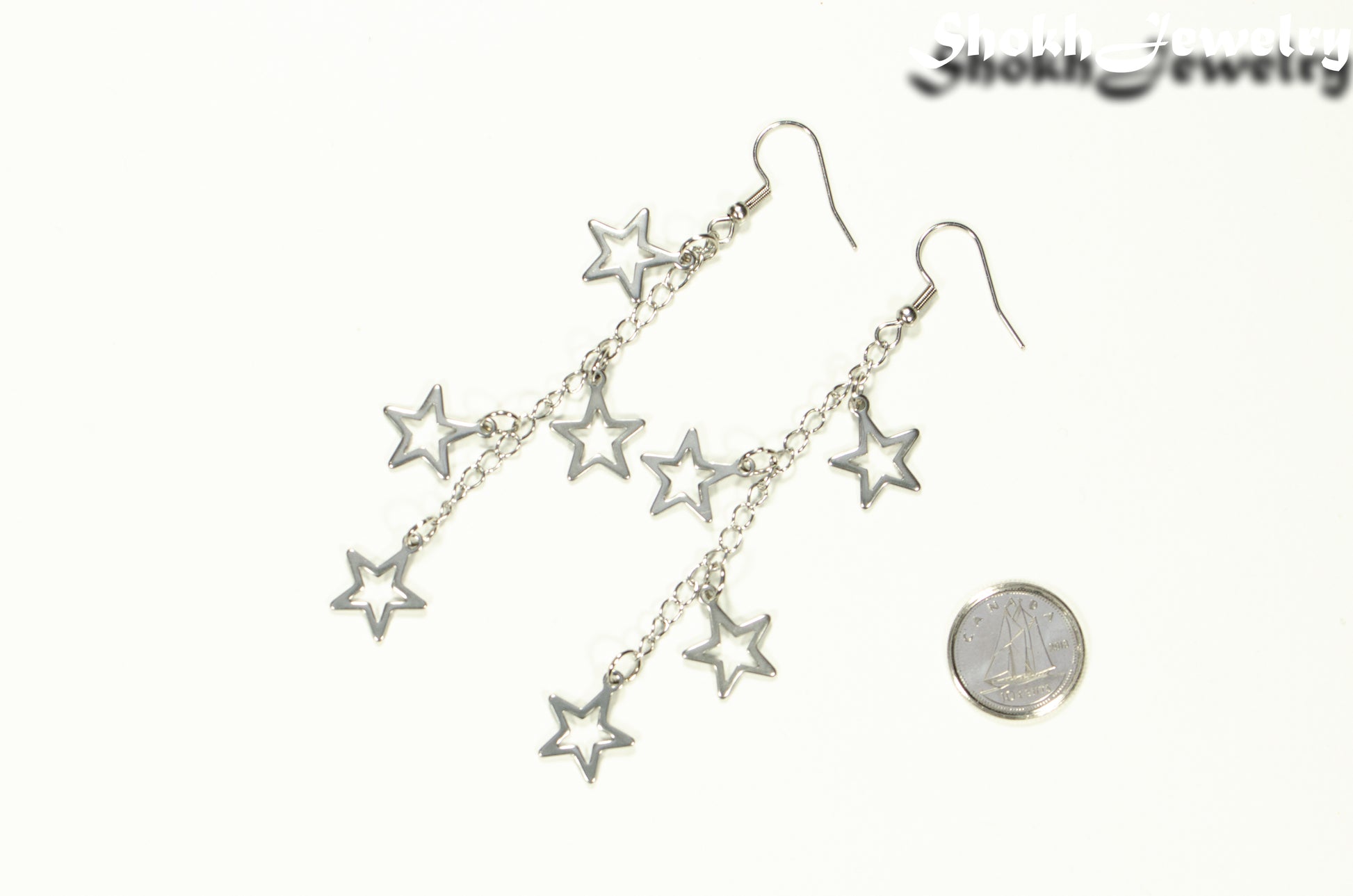 Stainless steel chain and 4 star earrings beside a dime.