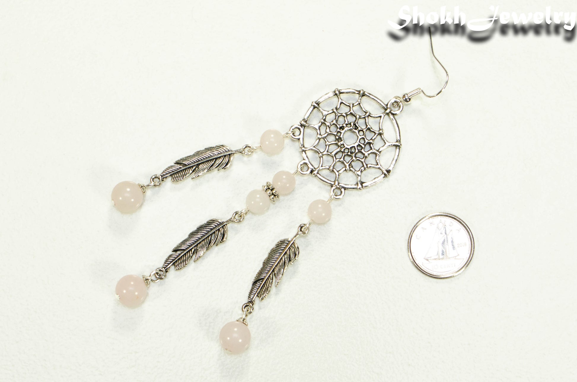 Extra Long Rose Quartz Dream Catcher Earring beside a dime.