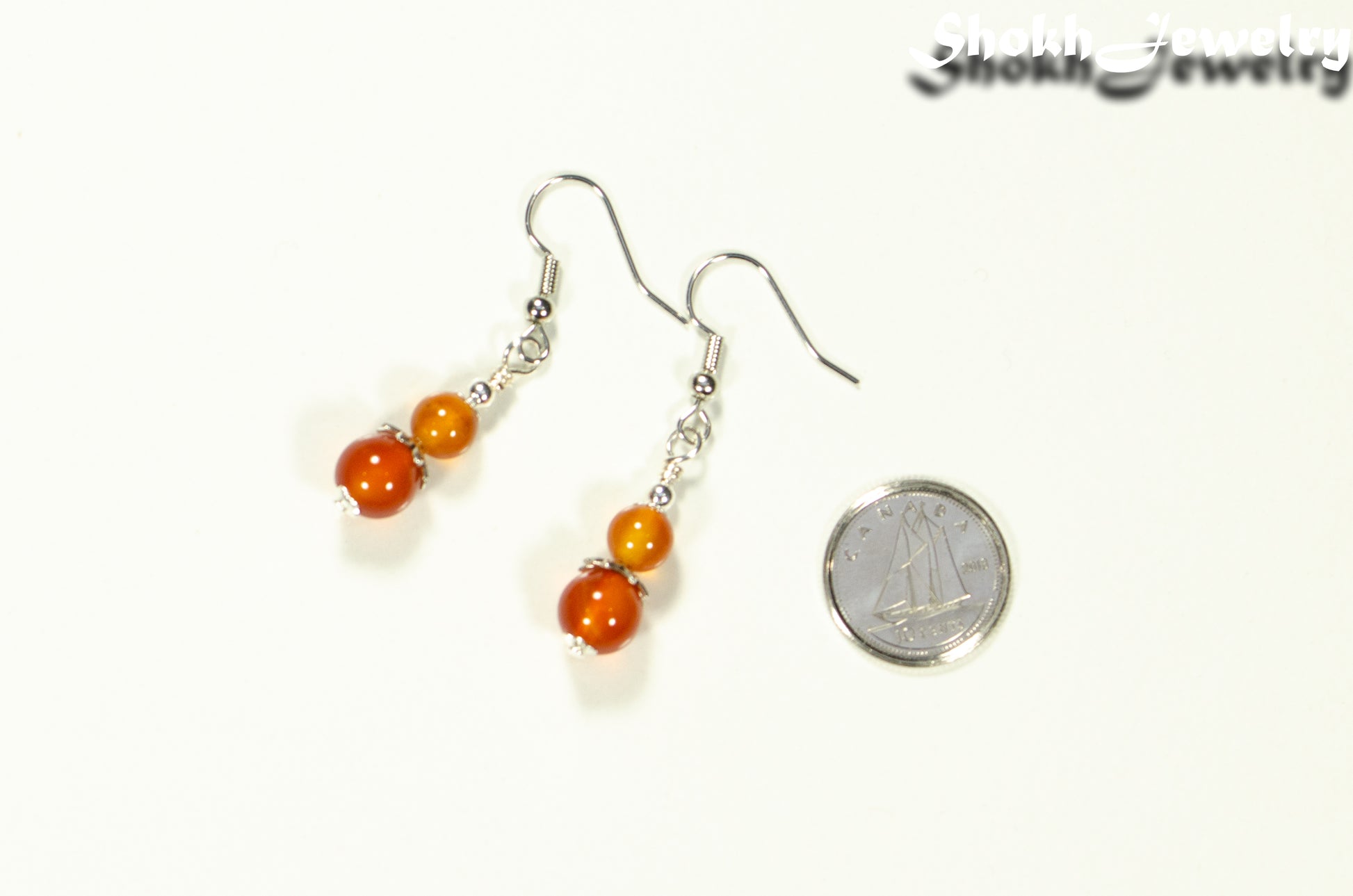 Small Natural Carnelian Earrings beside a dime.