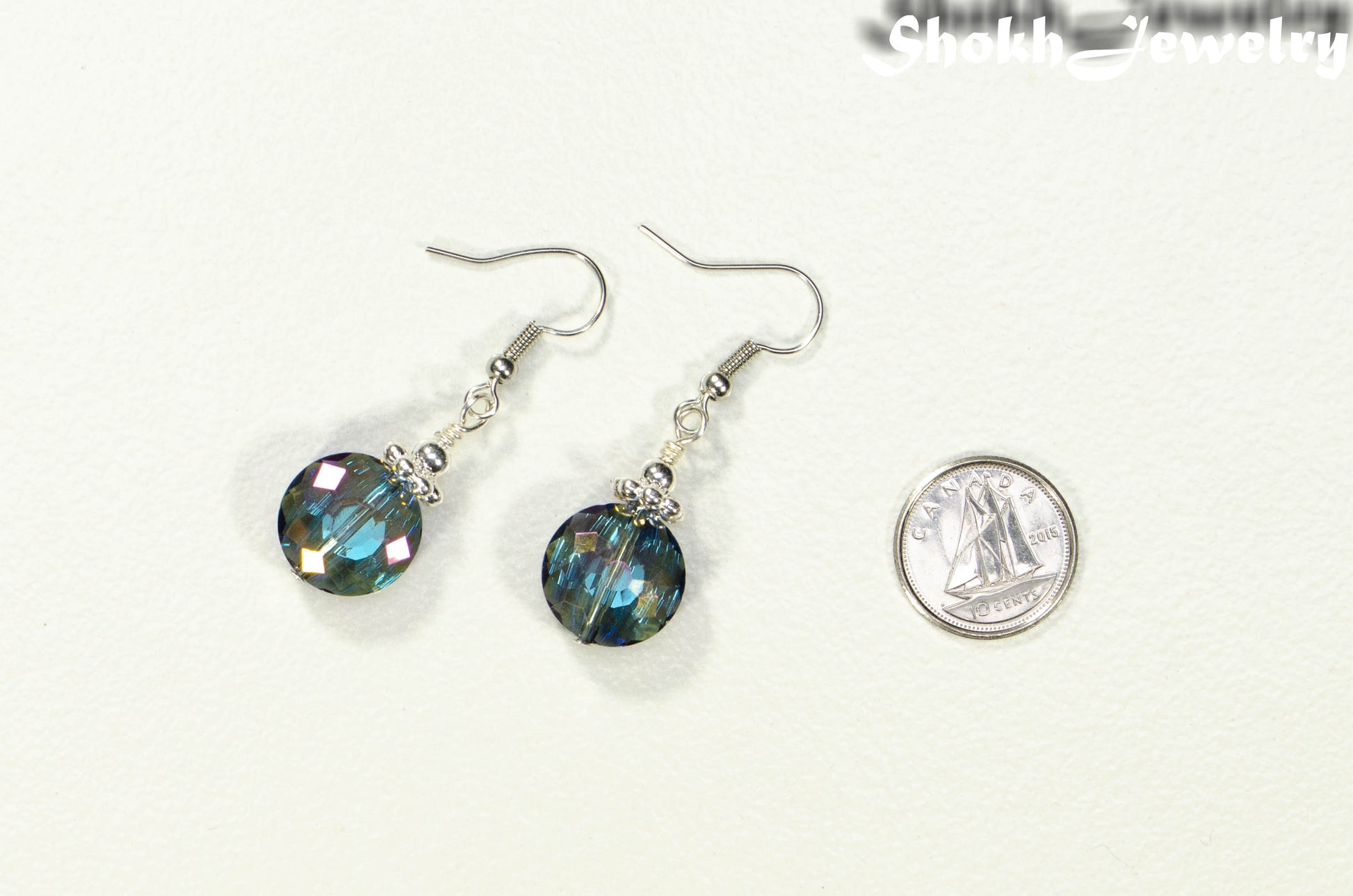 Iridescent Blue Glass Crystal Beads Earrings beside a dime.