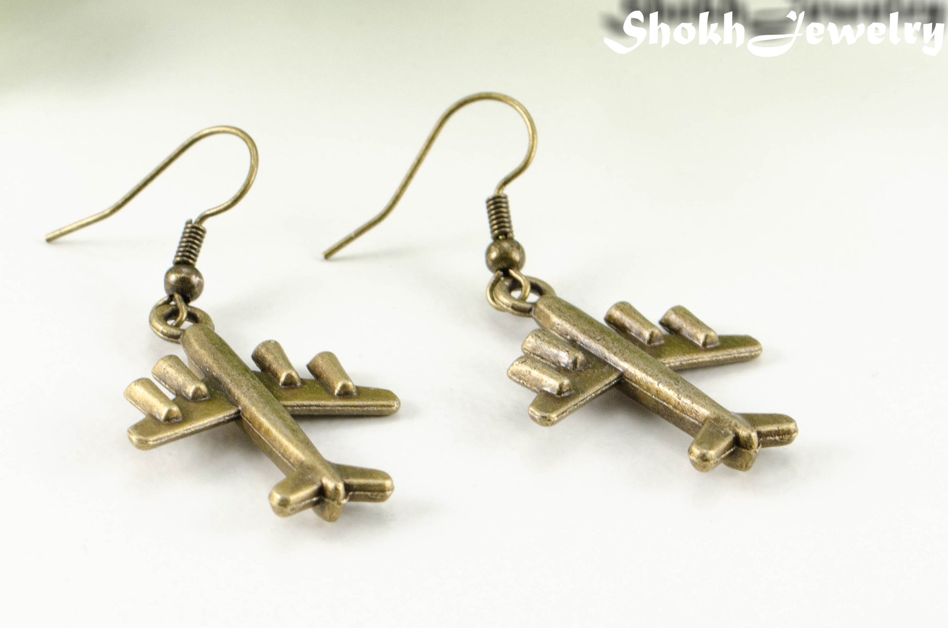 Close up of Antique Bronze 3D Plane Charm Earrings.