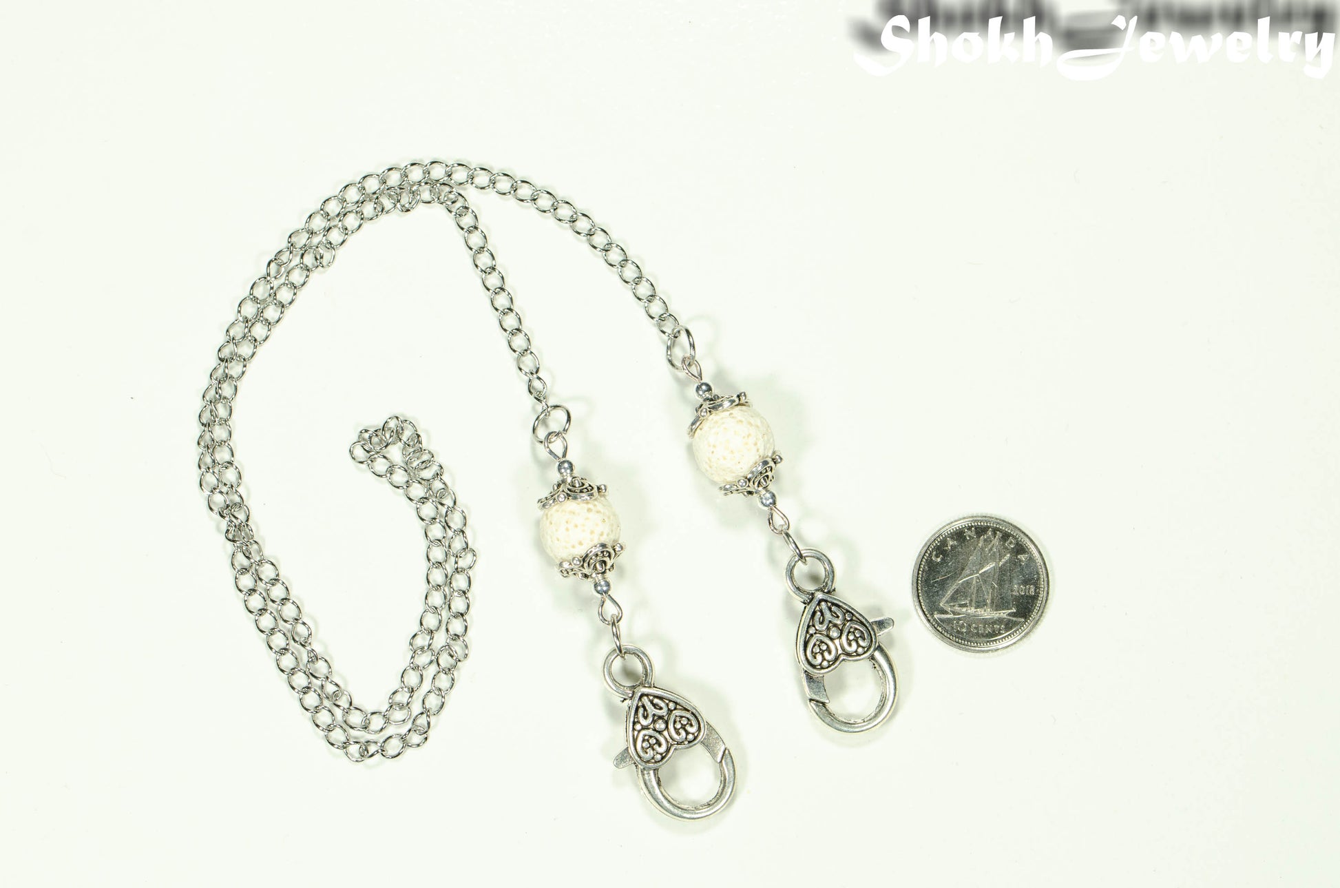 White  Lava Stone Eyeglass chain/Face Mask Lanyard beside a dime.