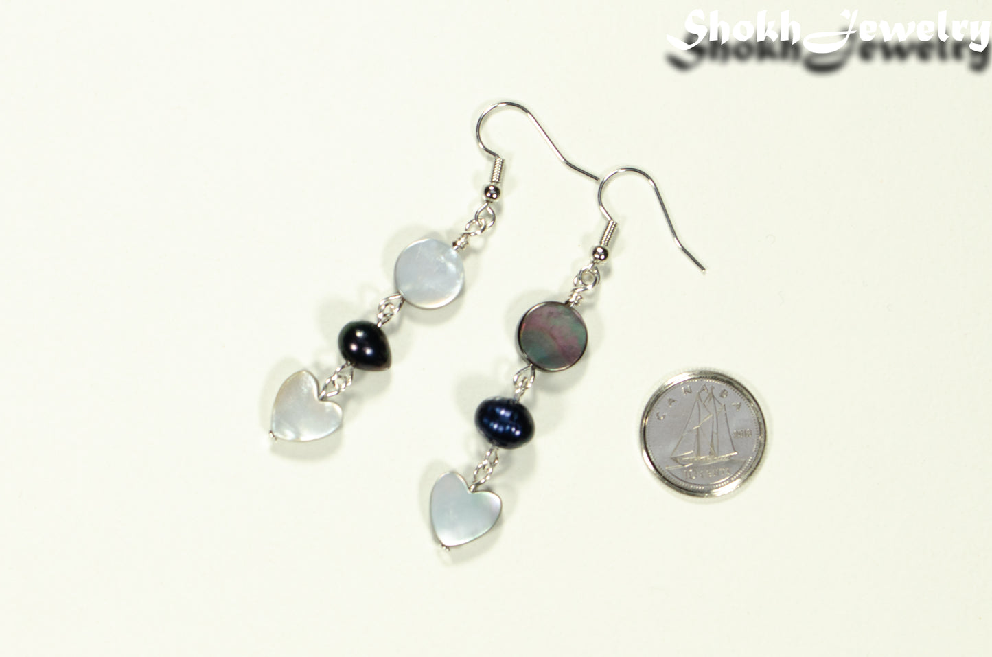 Grey Seashell and Black Pearl Earrings beside a dime.
