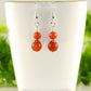 Small Matte Red Agate Earrings displayed on a tea cup.