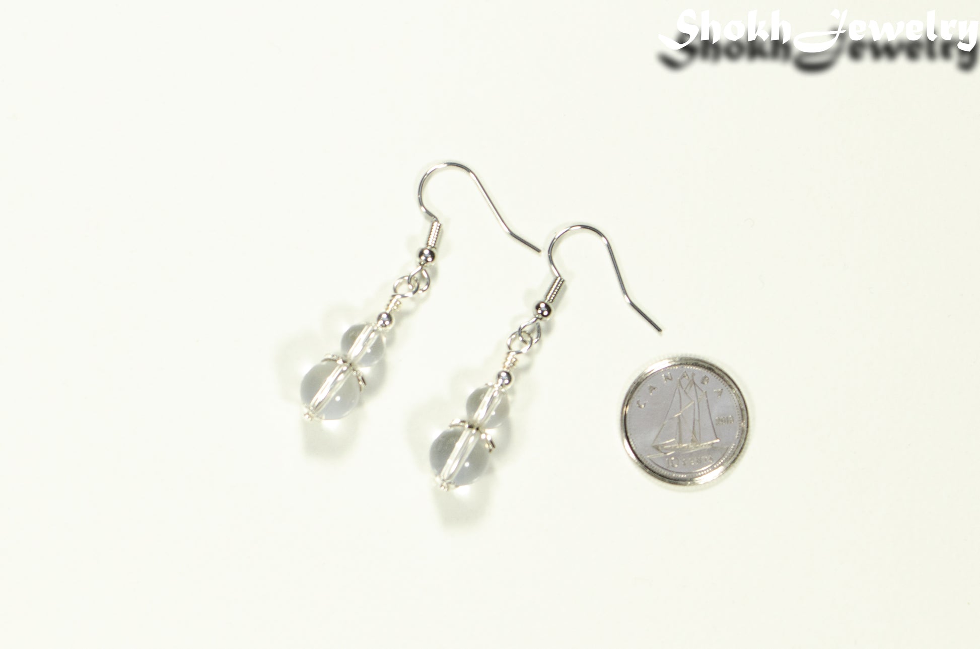 Small Clear Quartz Earrings beside a dime.