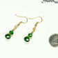 Small Dark Green Glass Bead Dangle Earrings beside a dime.