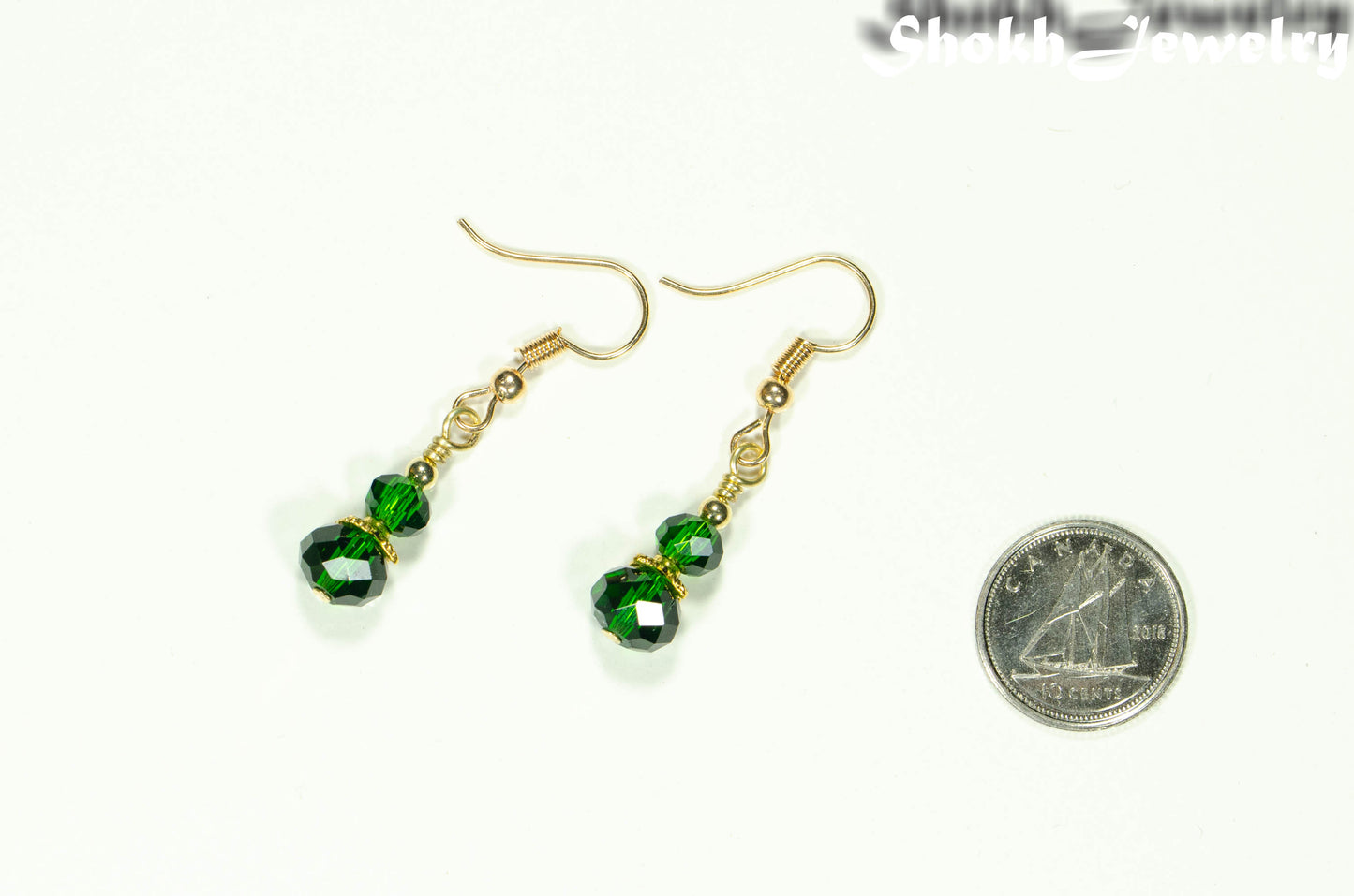 Small Dark Green Glass Bead Dangle Earrings beside a dime.