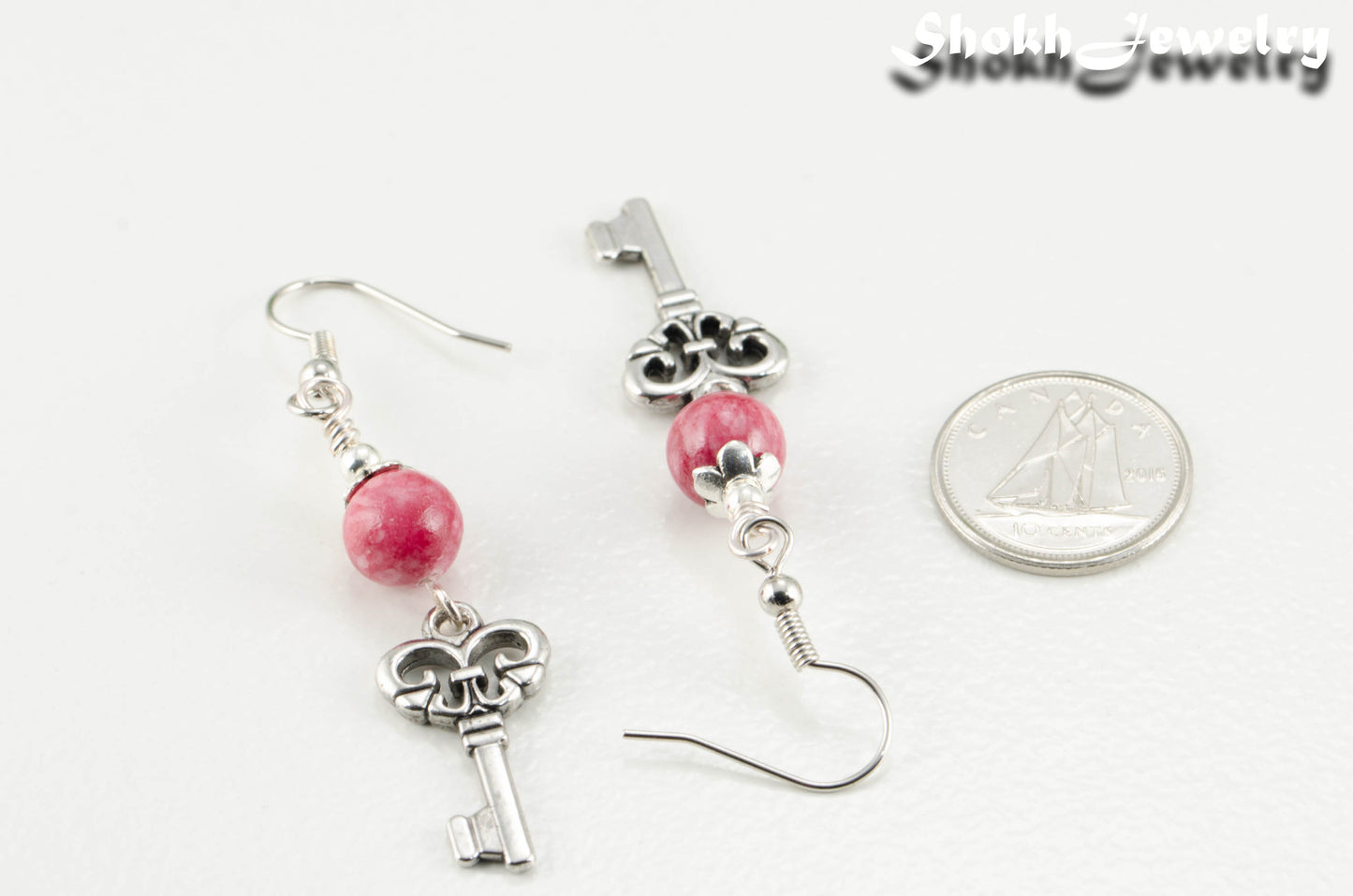 Red Quartzite and Key Charm Dangle Earrings beside a dime.