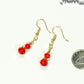 Small Red Glass Bead Dangle Earrings beside a dime.