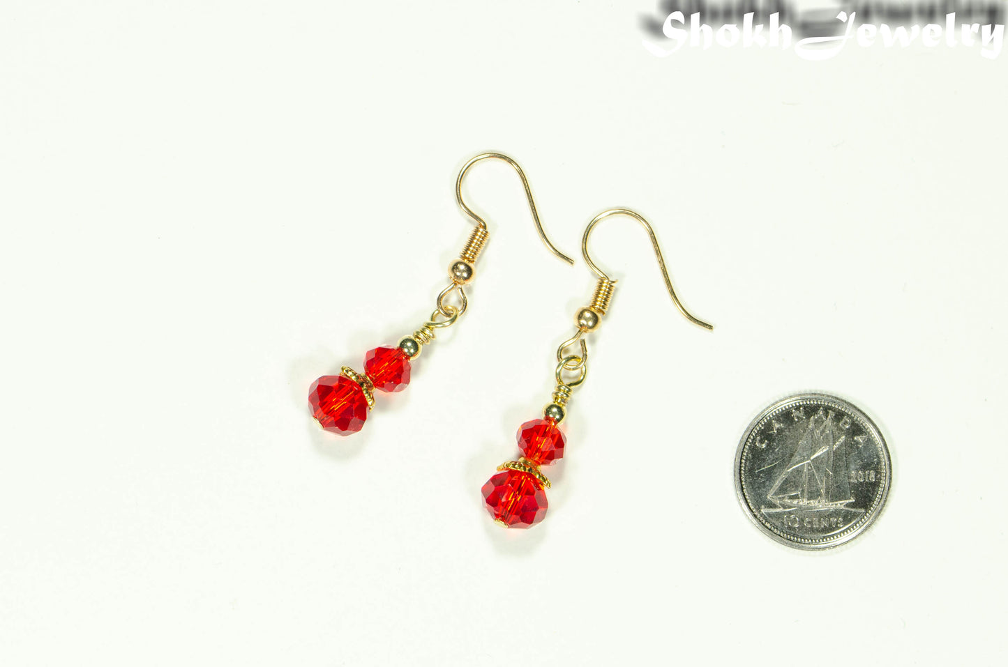 Small Red Glass Bead Dangle Earrings beside a dime.