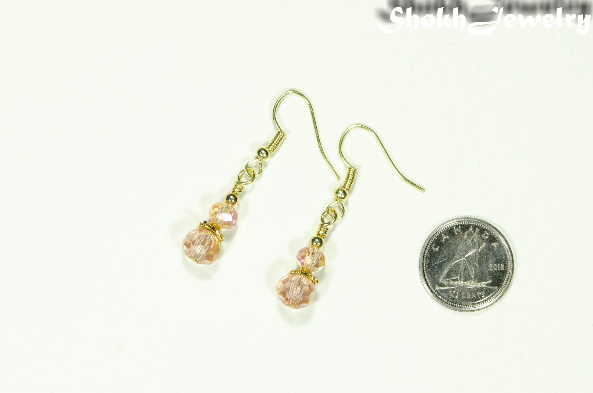 Small Light Pink Glass Bead Dangle Earrings beside a dime.