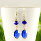 Close up of Navy Blue Oval Glass Dangle Earrings.