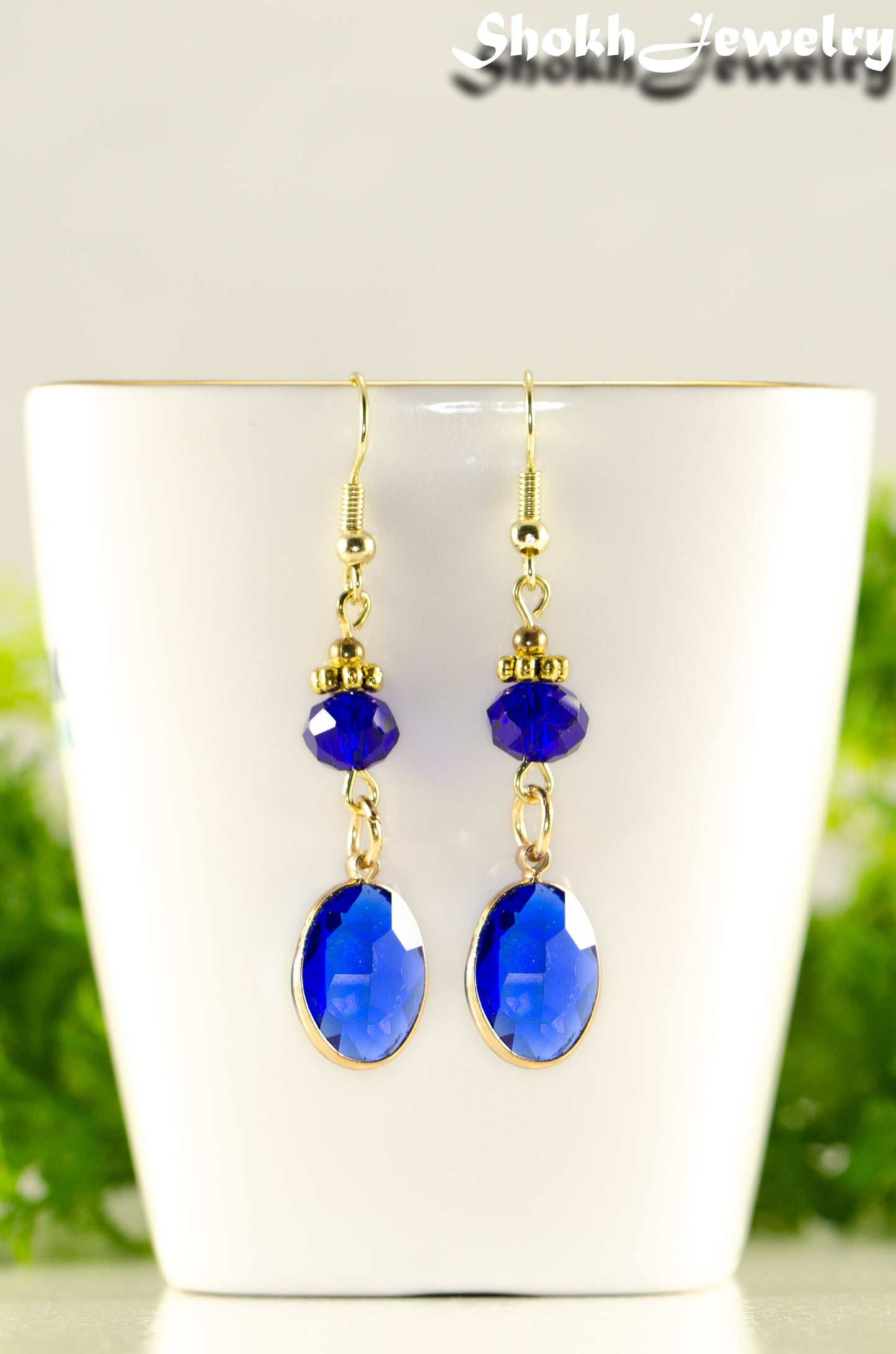 Close up of Navy Blue Oval Glass Dangle Earrings.