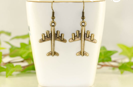 Antique Bronze 3D Plane Charm Earrings displayed on a tea cup.