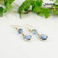 Light Blue Oval Glass Dangle Earrings with gold tone ear wires.