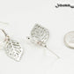 Filigree Silver Leaf Charm and Clear Glass Crystal Earrings beside a dime.