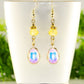 Light Yellow Oval Glass Dangle Earrings displayed on a tea cup.