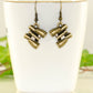 Antique Bronze Binocular Charm Earrings displayed on a tea cup.