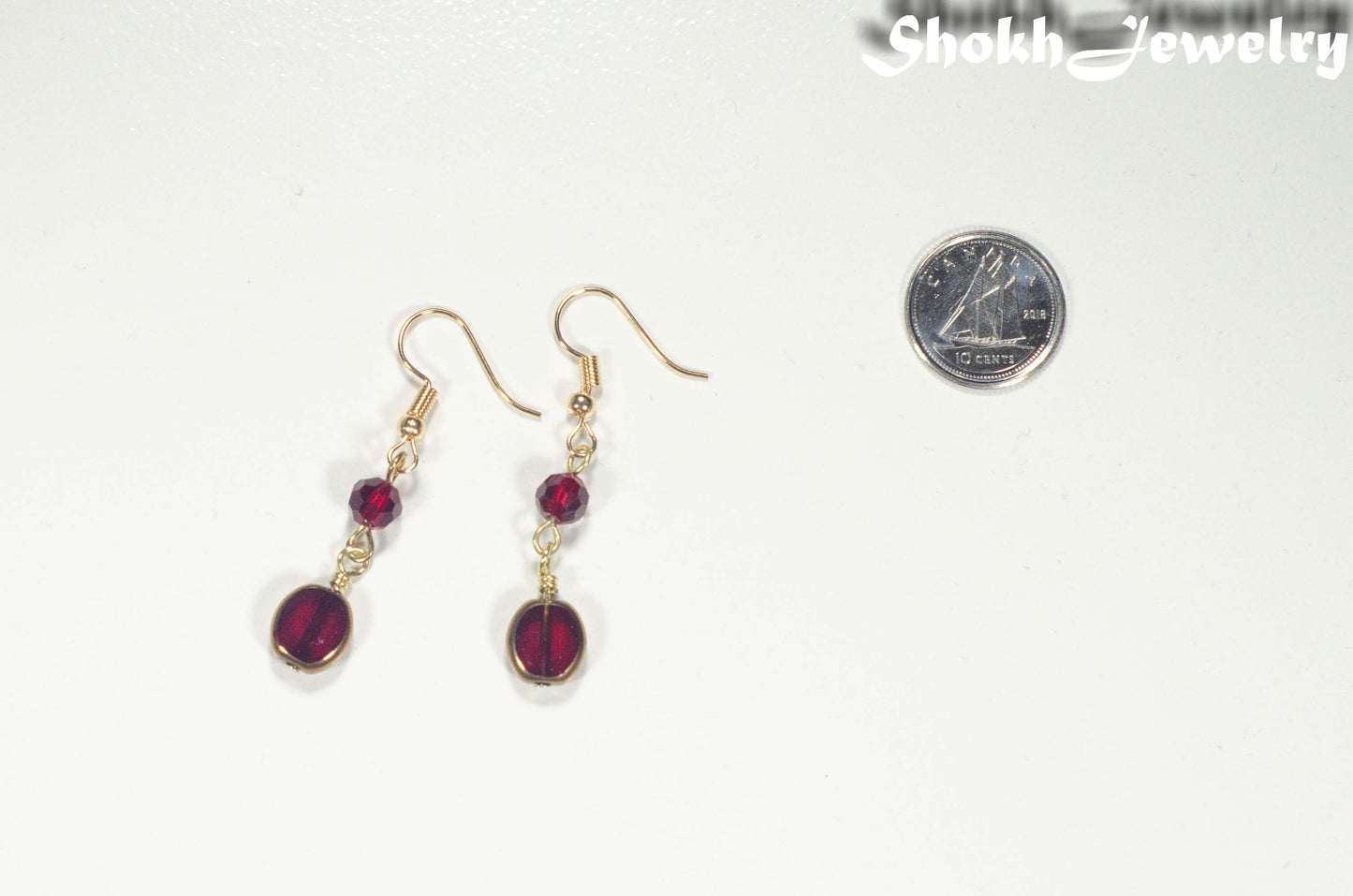 Dark Red and Gold Glass Bead Earrings beside a dime.