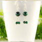 Genuine Malachite Dangle Earrings displayed on a tea cup.