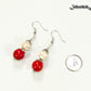 Red and White Howlite Dangle Earrings beside a dime.