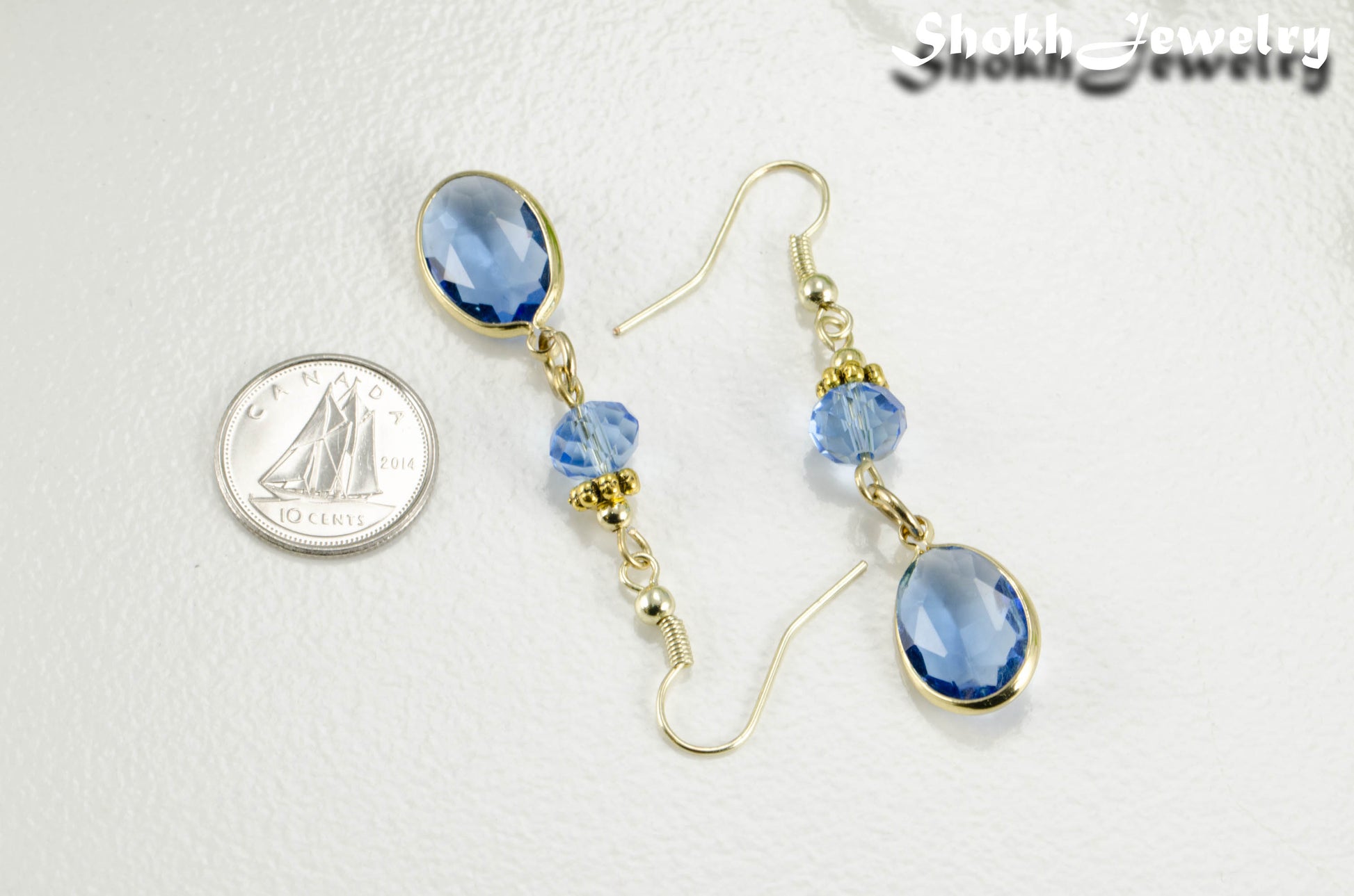 Light Blue Oval Glass Dangle Earrings beside a dime.