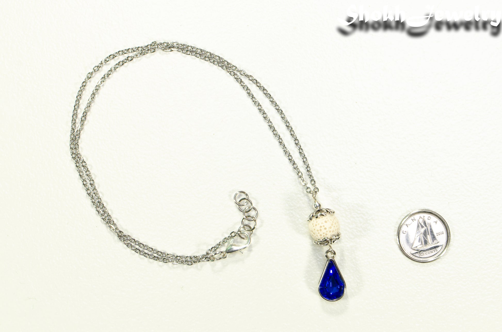 Lava Rock and Teardrop September Birthstone Choker Necklace beside a dime.