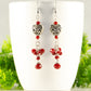 Tibetan Silver Heart and Red Beaded Cluster Earrings displayed on a coffee cup.