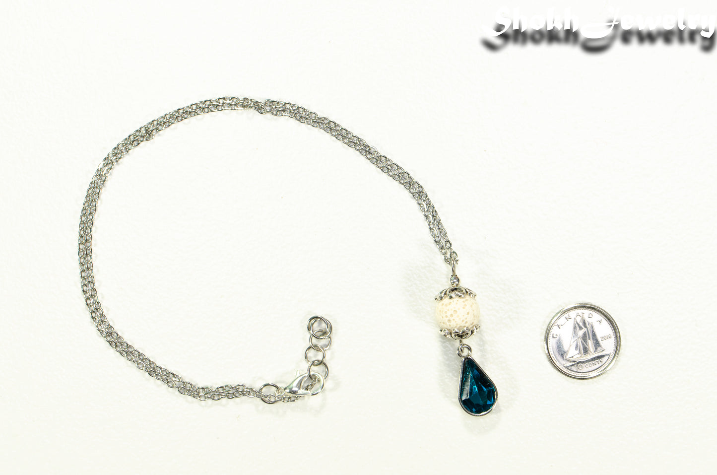 Lava Rock and Teardrop December Birthstone Choker Necklace beside a dime.