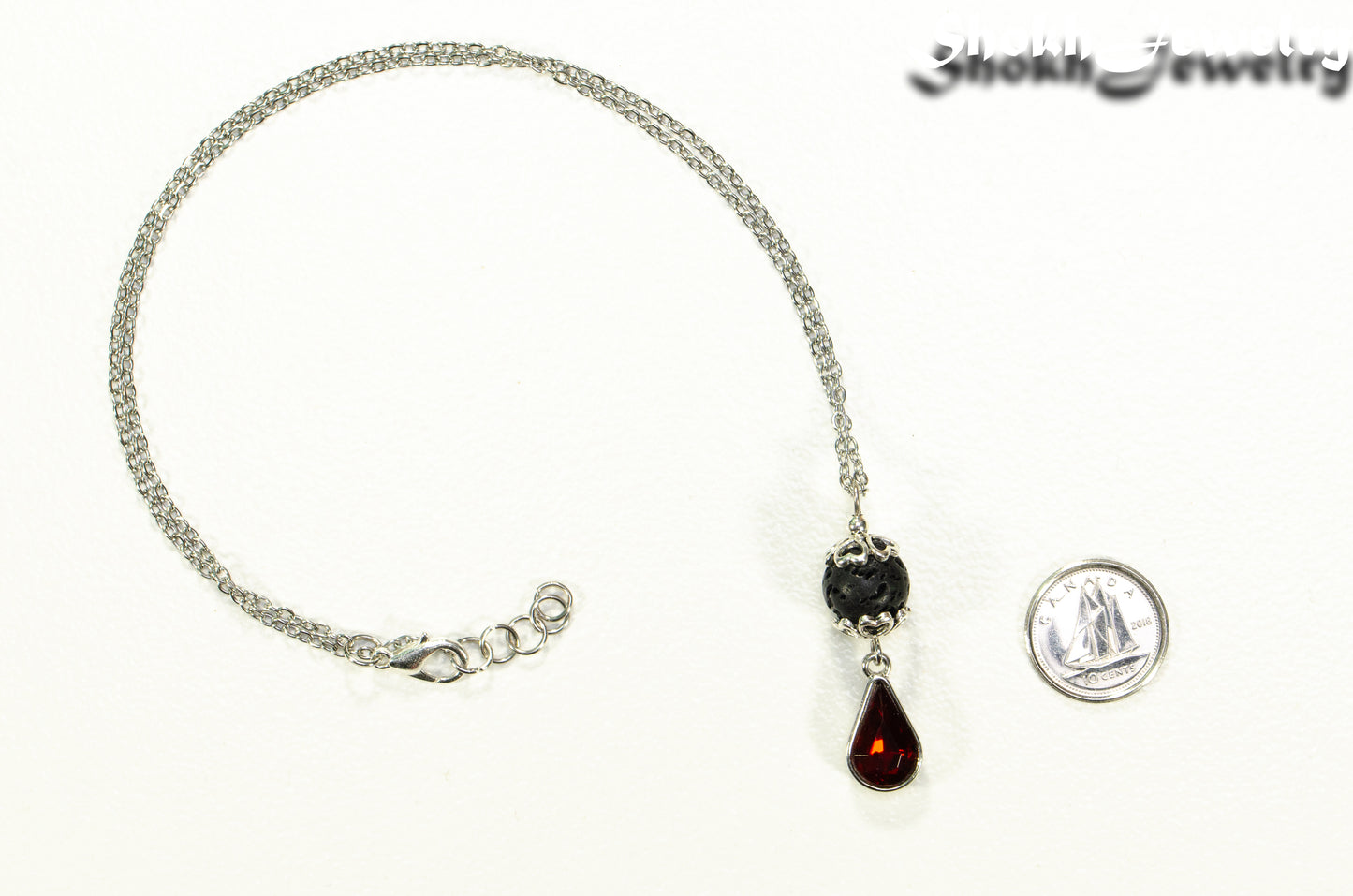 Lava Rock and Teardrop January Birthstone Choker Necklace beside a dime.