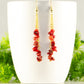 Long Gold Plated Chain and Red Dyed Bamboo Coral Chip Earrings displayed on a coffee mug.