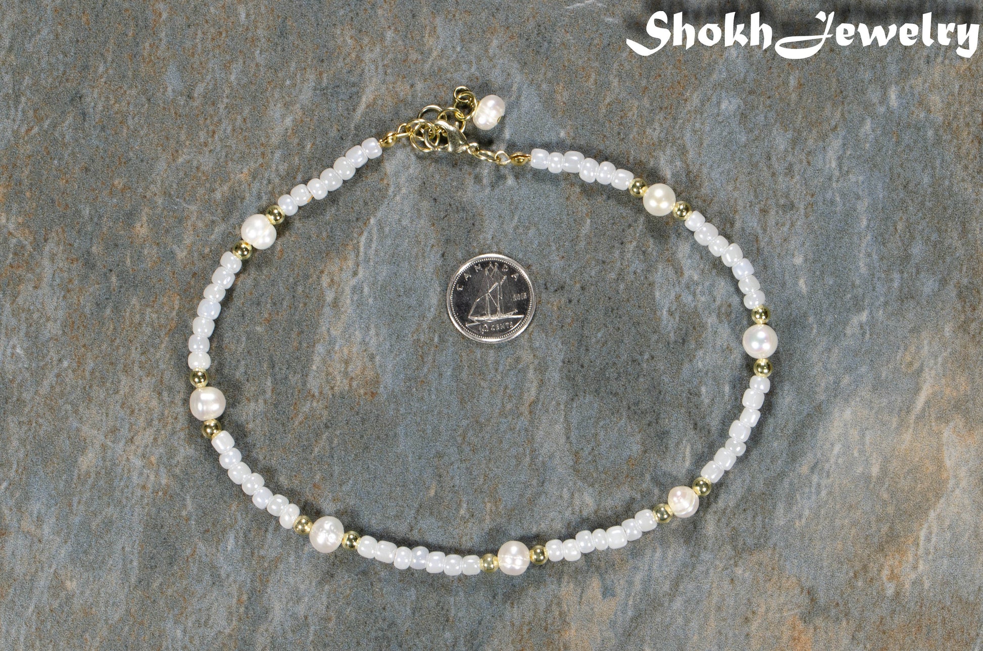 Freshwater Pearl and White Seed Bead Choker Necklace with Gold Plated Spacers beside a dime.